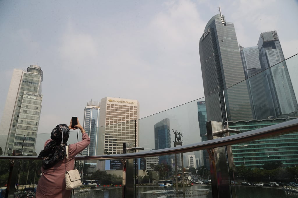 A woman takes pictures on a pedestrian bridge in Jakarta in July. Indonesia aims to become one of the world’s biggest economies by 2045. Photo: EPA-EFE