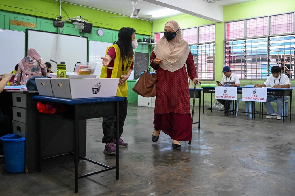 A woman carries her ballot before casting her vote during the state election at a polling station in Malaysia’s Selangor state on August 12. Photo: AFP