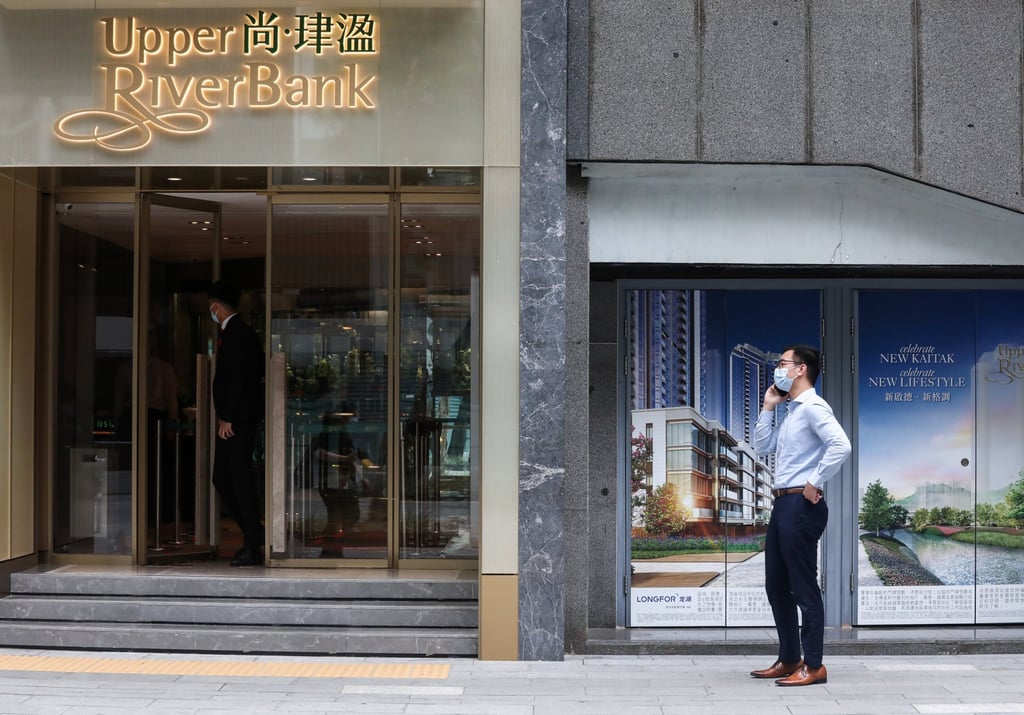 A man stands outside of the sales office of mainland developer Longfor Group and KWG’s Upper River Bank in East Kowloon’s Kai Tak. Photo: Jonathan Wong A man stands outside of the sales office of mainland developer Longfor Group and KWG’s Upper River Bank in East Kowloon’s Kai Tak. Photo: Jonathan Wong