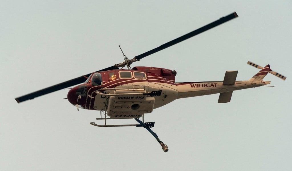A Wildcat helicopter flies above as the McDougall Creek wildfire continues to burn in West Kelowna, British Columbia. Photo: AFP