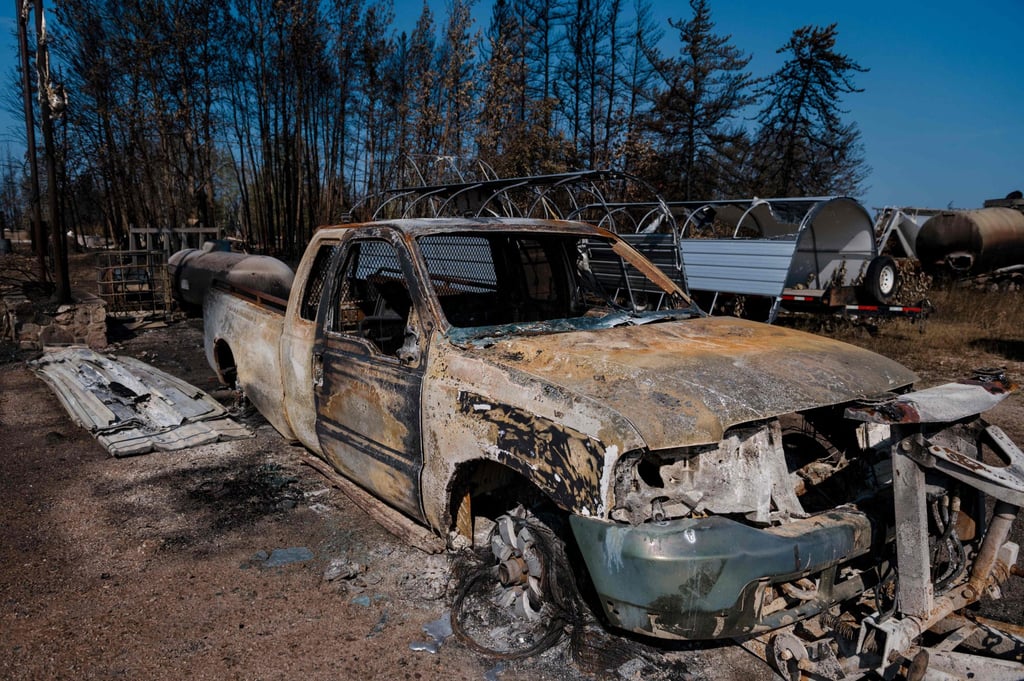 A charred vehicle is seen on the side of the road in Enterprise, Northwest Territories, Canada on Sunday. Photo: AFP