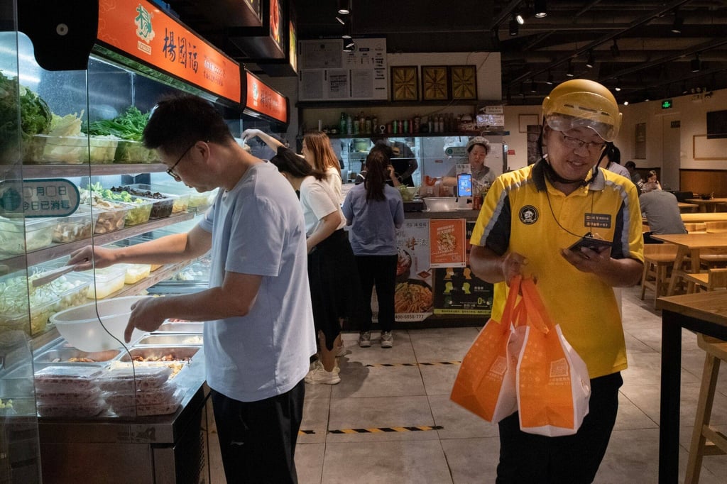 A Meituan courier pick ups lunch orders at a restaurant in Beijing. Photo: Bloomberg
