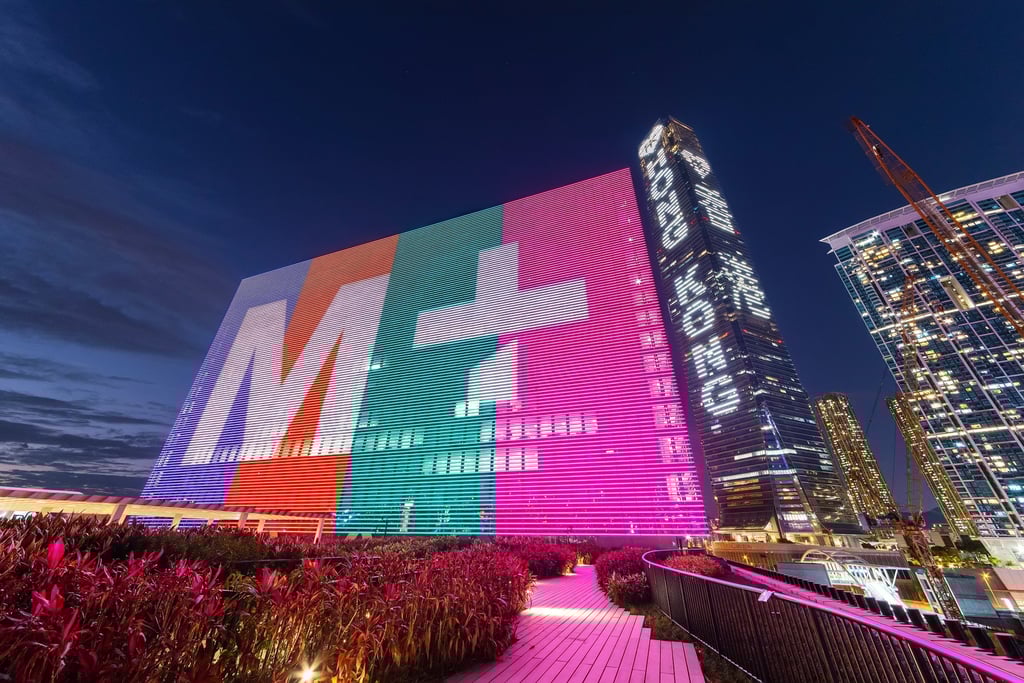 The giant illuminated M+ Facade at M+, Hong Kong’s global museum of visual culture – with the skyscraper International Commerce Centre behind – in West Kowloon Cultural District. Photo: Shutterstock