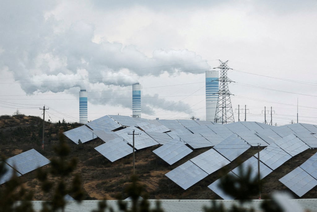 Smoke rises from chimneys near solar panels in Shaanxi province, China, on April 24, 2023. Photo: Reuters