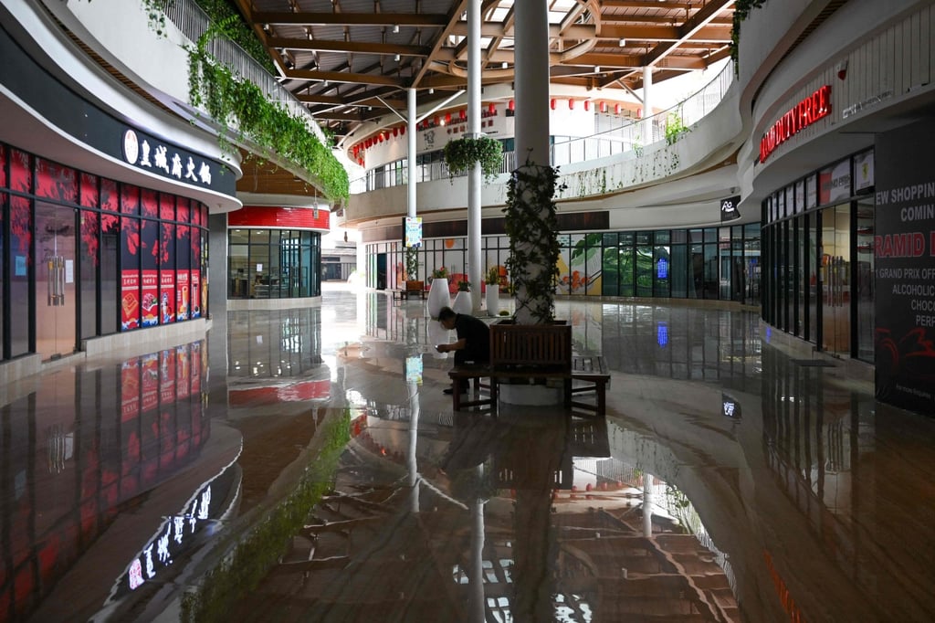 A man sits in the hallway in front of the empty Forest City mall in Gelang Patah in Malaysia’s Johor state. Photo: AFP