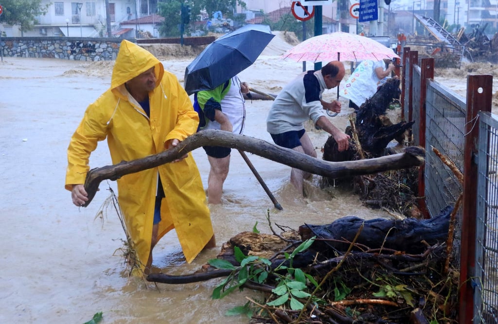 Residents remove debris from a flooded area in the town of Volos, central Greece on Tuesday. Photo: InTime News via AP