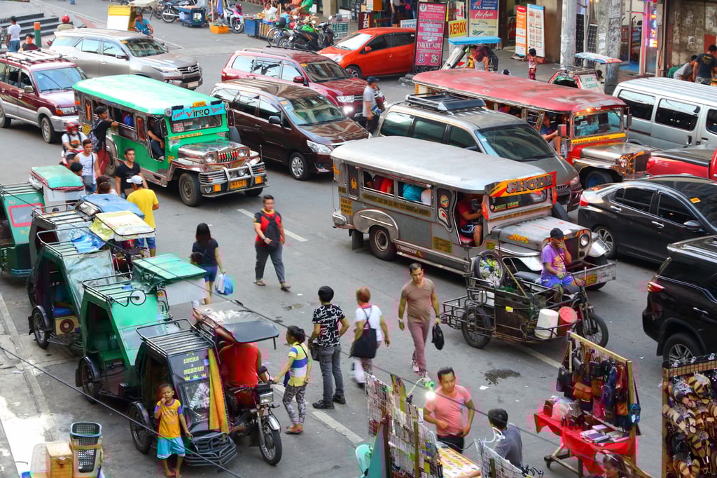 Brightly coloured, minibus-like Jeepneys in heavy traffic in Manila, in the Philippines. Photo: Shutterstock