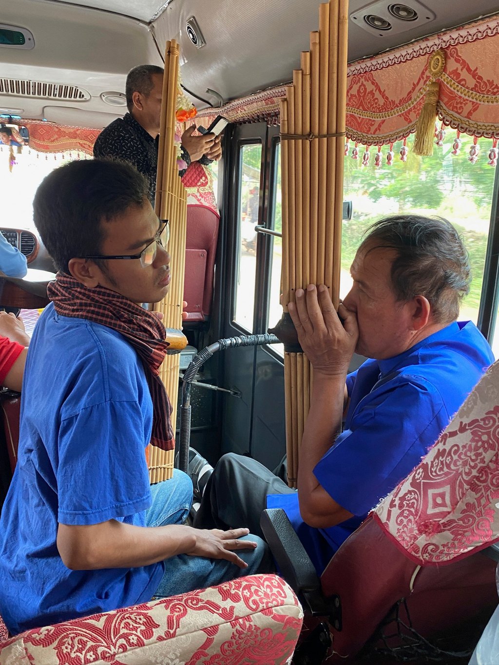 Nou Samnang (left) watches Mon Hai play the khen mouth organ. Photo: Patrick Scott Nou Samnang (left) watches Mon Hai play the khen mouth organ. Photo: Patrick Scott