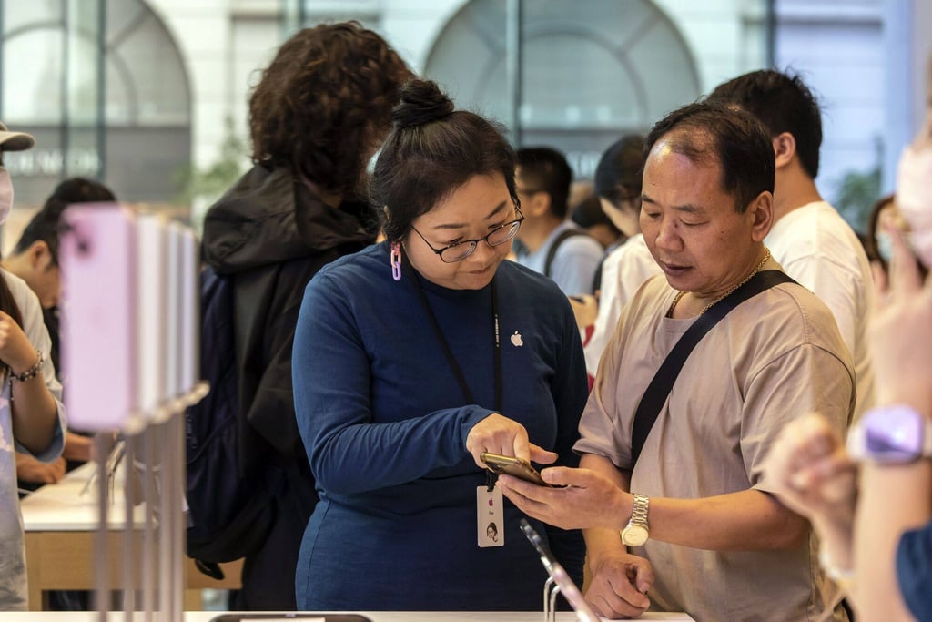 A customer checks out the new iPhone at an Apple store in Shanghai on Friday. Photo: Bloomberg A customer checks out the new iPhone at an Apple store in Shanghai on Friday. Photo: Bloomberg