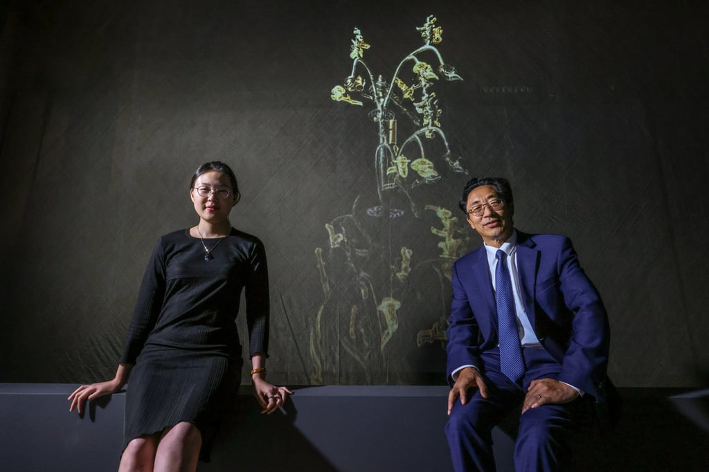 Hong Kong Palace Museum assistant curator Wang Shengyu (left) and head curator Jiao Tianlong (right) pose in front of a multimedia installation. Photo: May Tse