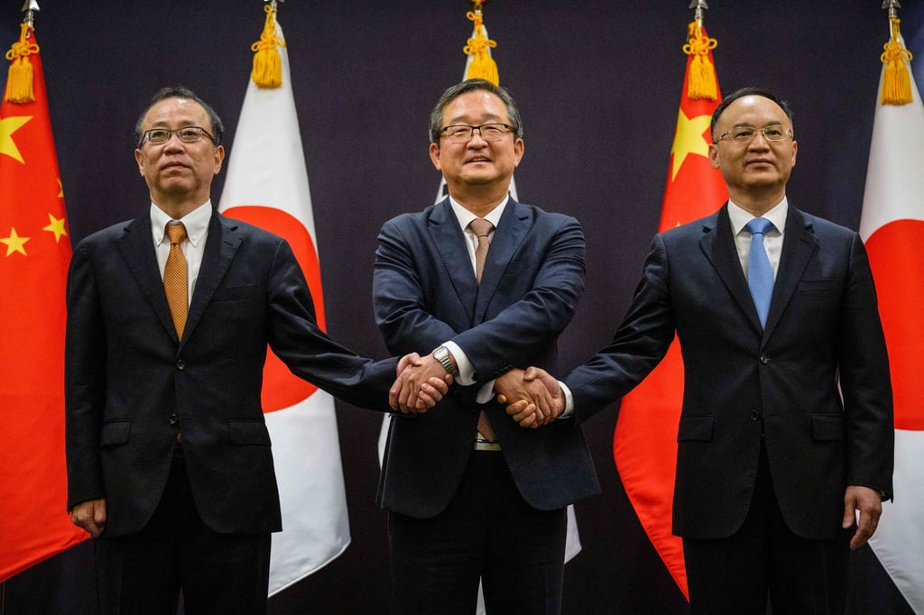 (From left) Takehiro Funakoshi, Chung Byung-won and Nong Rong shake hands before the talks. Photo: AFP