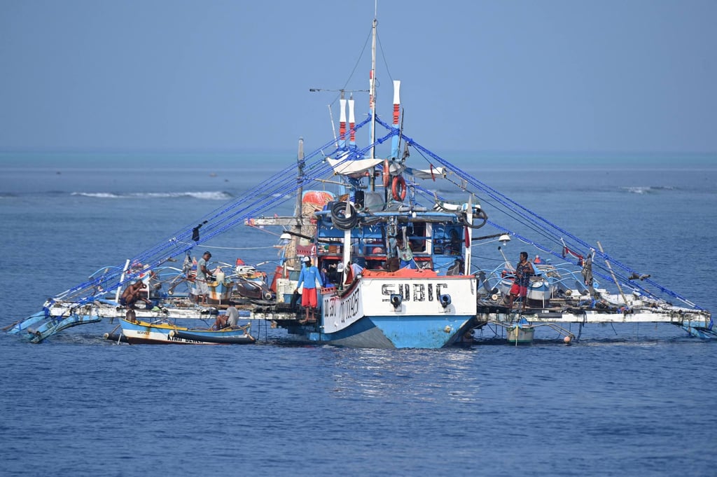 A Philippine fishing boat is anchored near the Chinese-controlled Scarborough Shoal (back) in the disputed South China Sea. Photo: AFP A Philippine fishing boat is anchored near the Chinese-controlled Scarborough Shoal (back) in the disputed South China Sea. Photo: AFP
