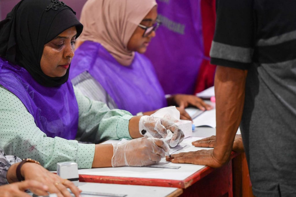 An election official marks with ink the finger of a voter at a polling station during Maldives’ presidential election on Saturday. Photo: AFP An election official marks with ink the finger of a voter at a polling station during Maldives’ presidential election on Saturday. Photo: AFP