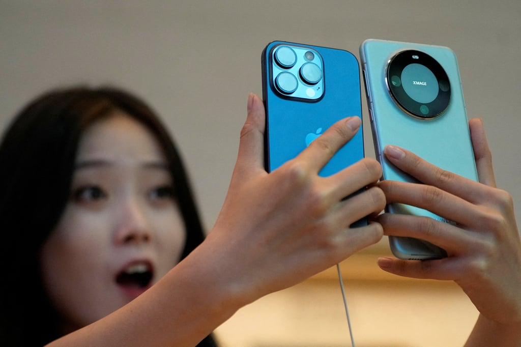 A woman compares a new iPhone 15 Pro with Huawei Technologies’ Mate 60 Pro handset at an Apple Store in Shanghai on September 22. Photo: Reuters