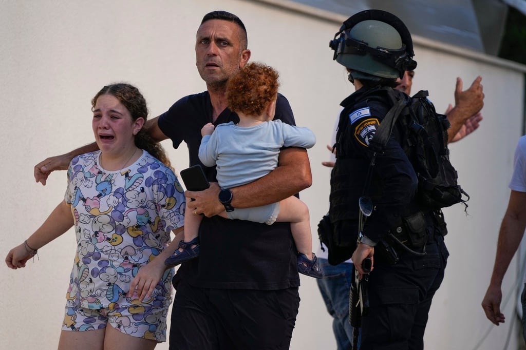 Israeli police evacuate a family from a site hit by a rocket fired by Hamas in southern Israel. Photo: AP