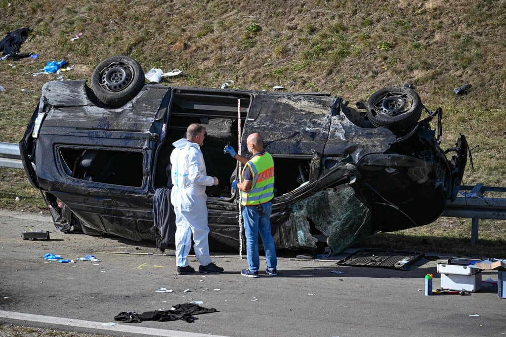 Police officers work at the accident site by the overturned van on the motorway near Waldkraiburg in southern Germany. Photo: AFP