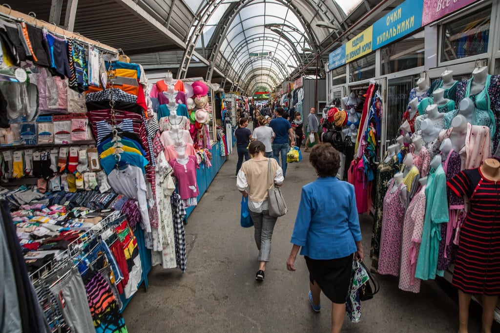 Shoppers walk past stalls in Almaty’s Green Bazaar. For over a decade, Kazakhstan has been experiencing a brain drain of skilled and educated workers in many key industries. Photo: Bloomberg