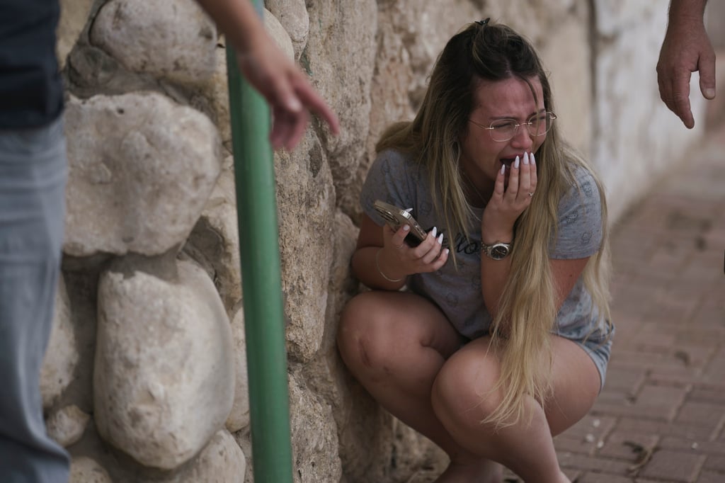 Israelis take cover from incoming rocket fire from the Gaza Strip in Ashqelon, southern Israel. Iran has celebrated Hamas’ attack as a success. Photo: AP Israelis take cover from incoming rocket fire from the Gaza Strip in Ashqelon, southern Israel. Iran has celebrated Hamas’ attack as a success. Photo: AP