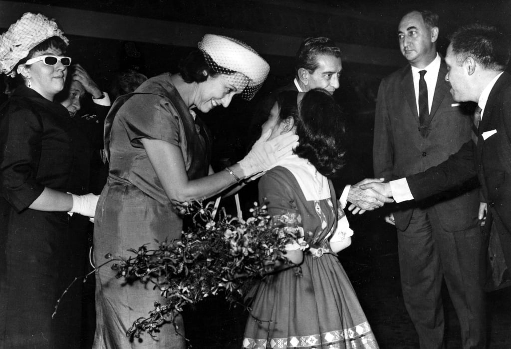 Mateos (back middle) at Kai Tak Airport with his wife, as she is presented with a bouquet of flowers. Photo: SCMP