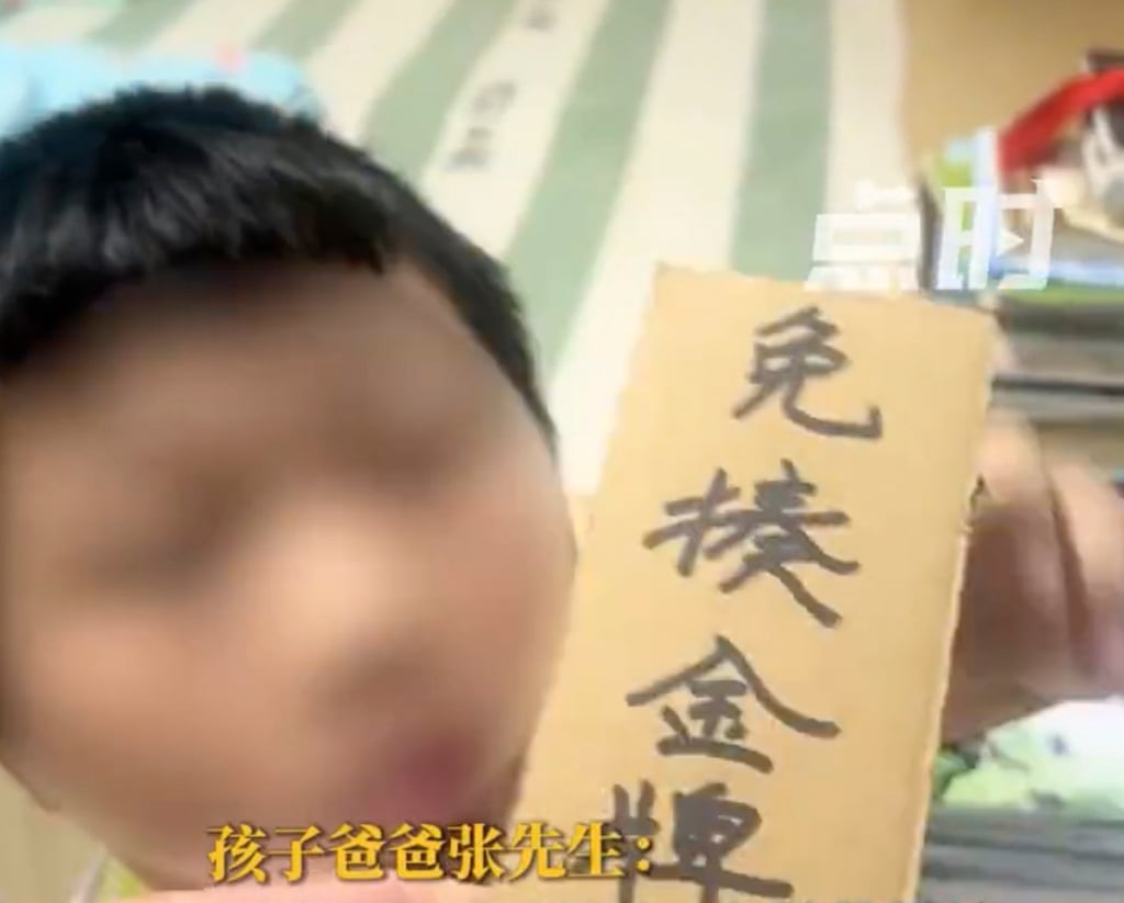 The father gave his son a cardboard “plaque” to mark the start of a month free of corporal punishment. Photo: Weibo The father gave his son a cardboard “plaque” to mark the start of a month free of corporal punishment. Photo: Weibo