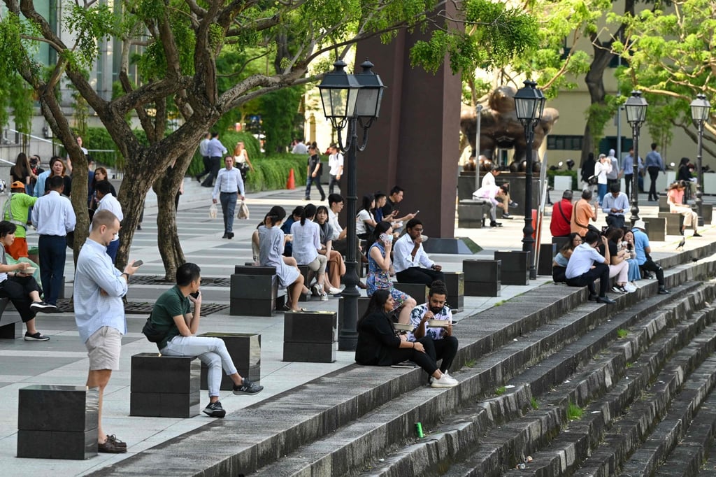 People relax along the quay at lunch time next to Raffles Place in Singapore’s financial district on January 12, 2023. Photo: AFP