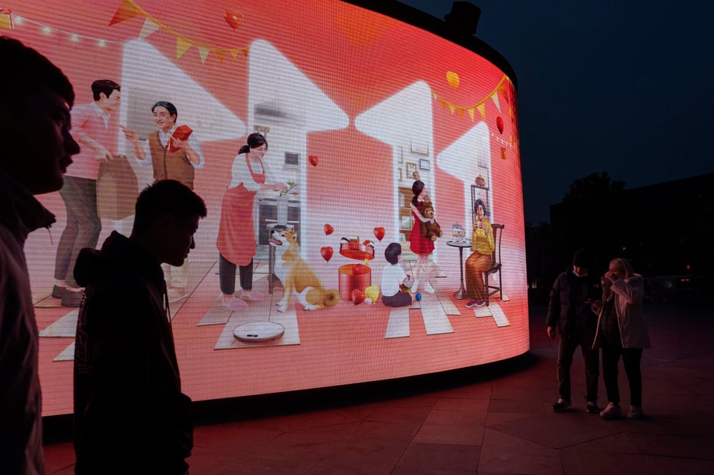 Shoppers at a mall in Beijing walk by a Singles’ Day advertisement on November 9, 2022. Photo: AP Shoppers at a mall in Beijing walk by a Singles’ Day advertisement on November 9, 2022. Photo: AP