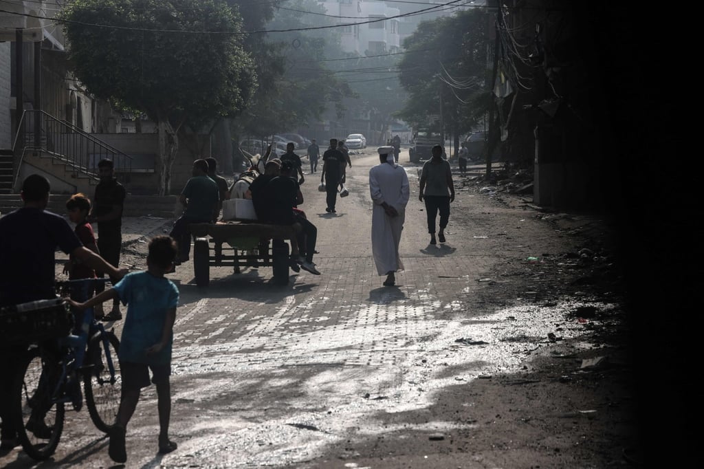 People walk along a street in the aftermath of Israeli strikes in Gaza City. Photo: AFP