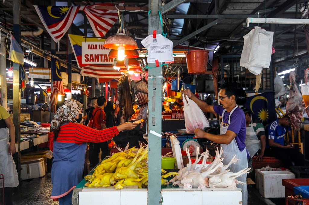 A customer buys a chicken at a wet market in Kuala Lumpur. Photo: EPA-EFE