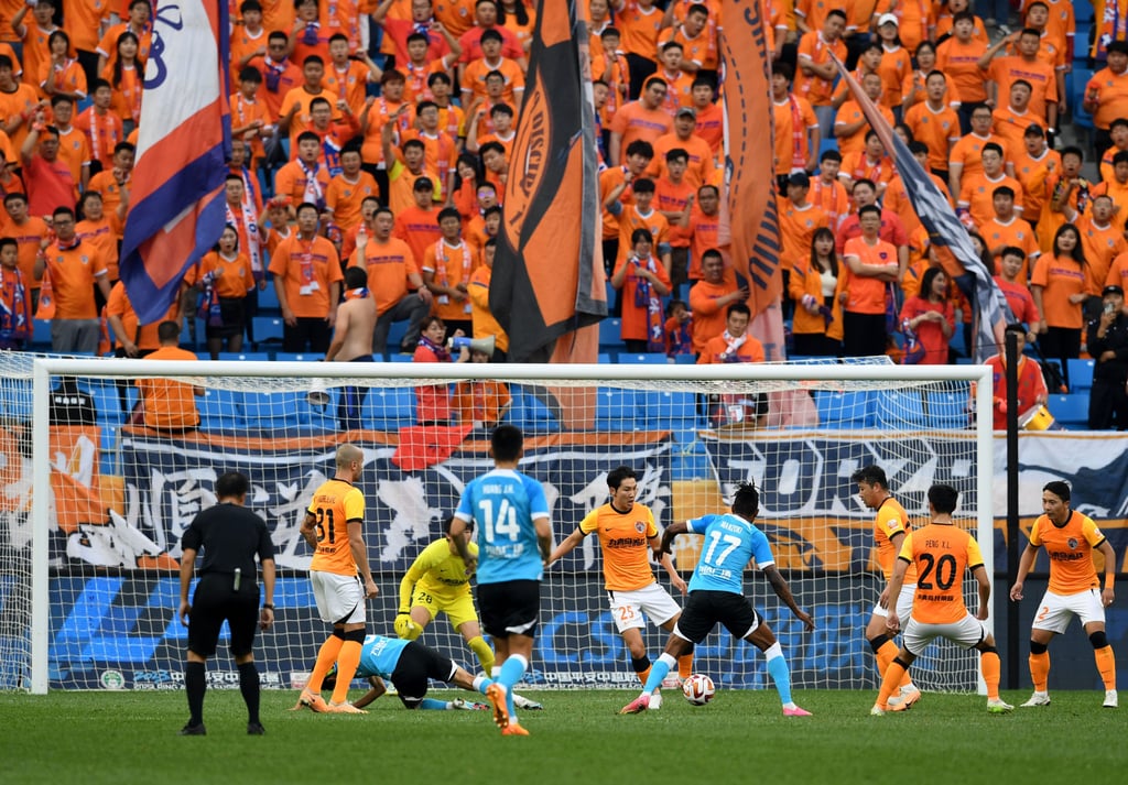 Elsewhere in the CSL’s penultimate round, Dalian Pro (in blue) and Qingdao Hainiu shared a 2-2 draw. Photo: Xinhua