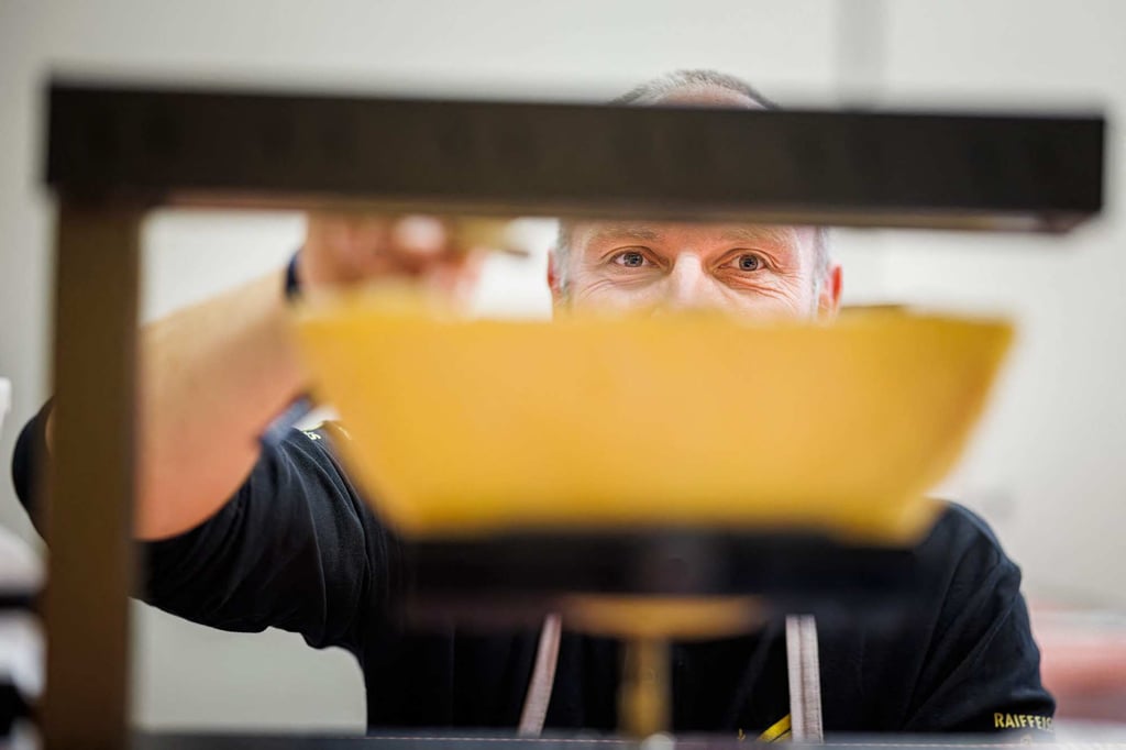 A “scaper” checks a piece of cheese before scraping a raclette during the first Raclette World Championships in Morgins, Switzerland. Photo: AFP A “scaper” checks a piece of cheese before scraping a raclette during the first Raclette World Championships in Morgins, Switzerland. Photo: AFP