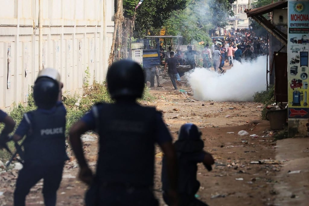 Police personnel fire tear shell to disperse striking garment workers. Photo: AFP Police personnel fire tear shell to disperse striking garment workers. Photo: AFP