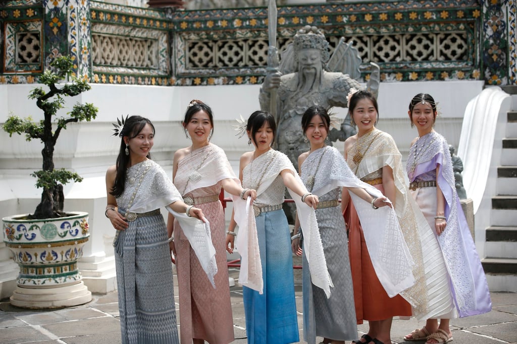 Chinese tourists dressed in traditional Thai costumes from a rental shop pose for a photograph at a temple in Bangkok on Thursday. Photo: EPA-EFE