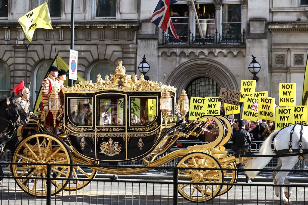 Britain’s King Charles III and Queen Camilla travel past protesters holding ‘Not My King’ placards on Tuesday, ahead of the King’s Speech. Photo: AFP