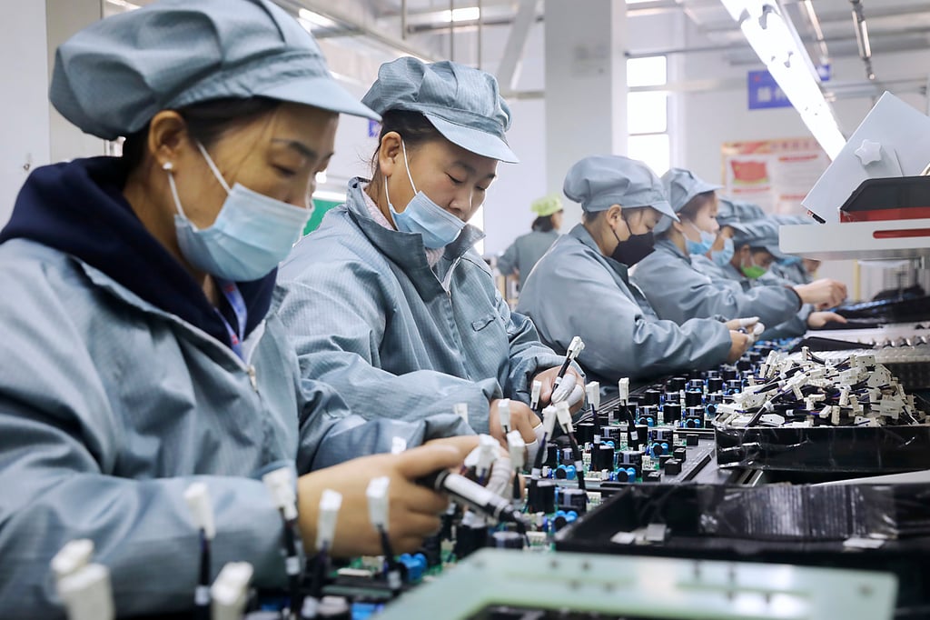 Workers wearing face masks assemble electronic parts at a factory in Huaibei in central China’s Anhui Province. Photo: AP Workers wearing face masks assemble electronic parts at a factory in Huaibei in central China’s Anhui Province. Photo: AP