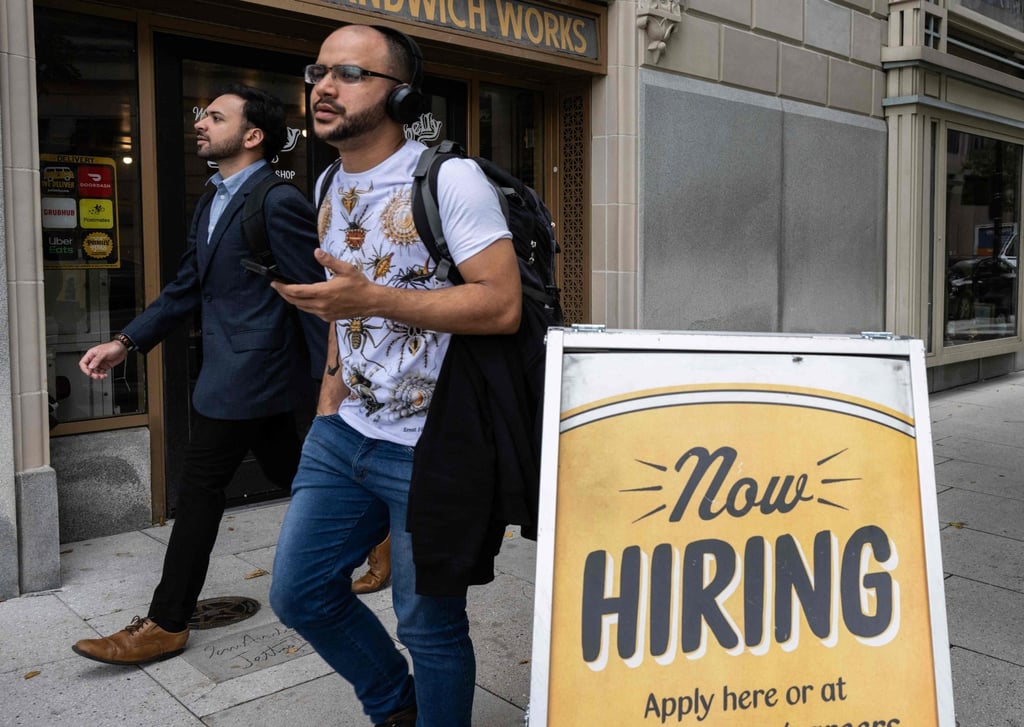 People walk past a restaurant with a hiring sign outside in Washington on October 5. Hiring in the US private sector rebounded in October, with education and healthcare creating the most jobs. Policymakers are eyeing the pace of job growth as they work to rein in inflation by lifting interest rates to cool demand. Photo: AFP