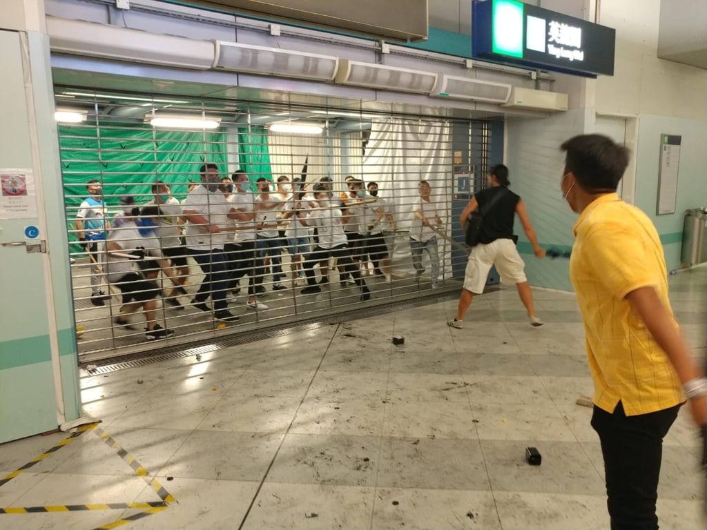 Men dressed in white and a black-clad protester face off at the Yuen Long MTR Station. Photo: Handout Men dressed in white and a black-clad protester face off at the Yuen Long MTR Station. Photo: Handout