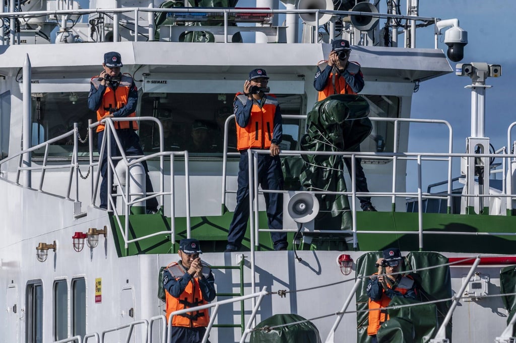 Chinese coastguard personnel take pictures and videos of Philippine Coast Guard (PCG) ships during the PCG’s resupply mission to the BRP Sierra Madre vessel in the disputed South China Sea. Photo: Bloomberg