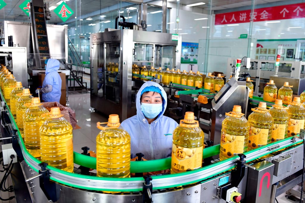 Workers are seen on a production line of a cooking oil plant in east China’s Shandong province on Sunday. Singapore’s central bank cited a slowing Chinese economy among the risks to financial stability. Photo: Xinhua