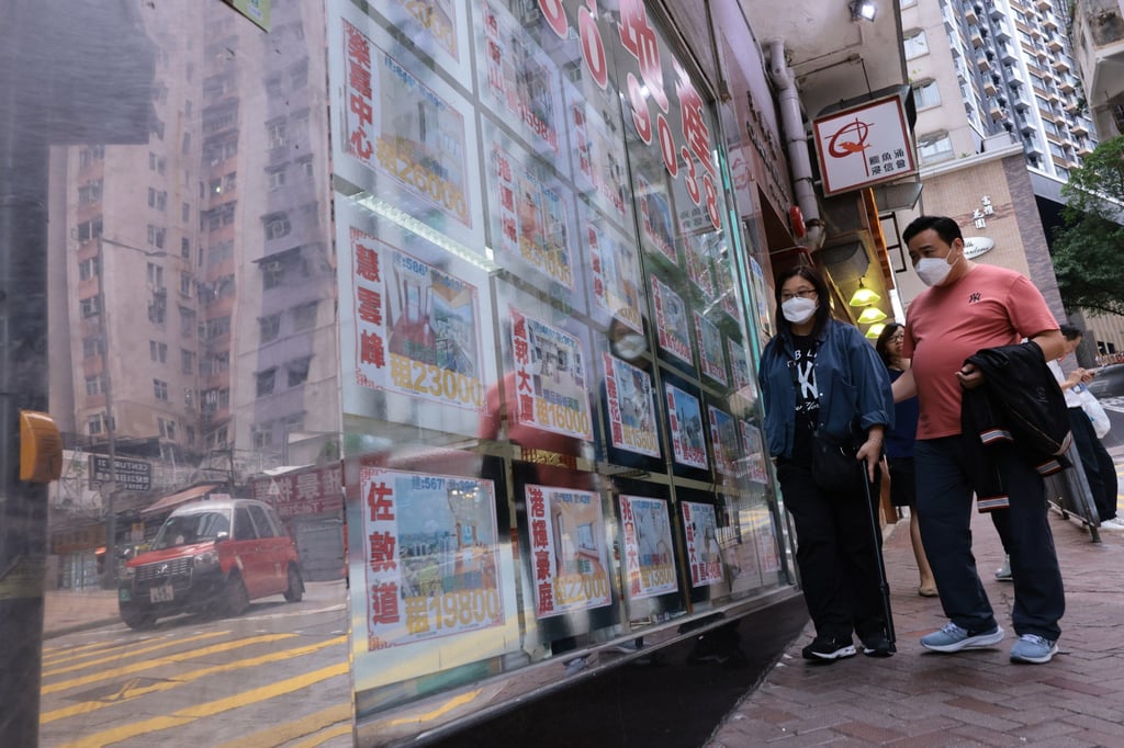 People pass residential property advertisements at a real estate agency in North Point on October 29, 2023. Photo: May Tse