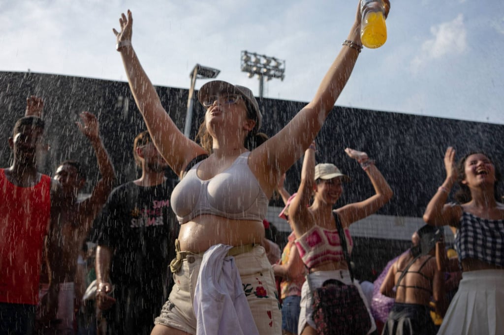 Fans cool off as they queue outside the Nilton Santos Olympic Stadium before Taylor Swift’s later-postponed concert on November 18, 2023. Photo: AFP