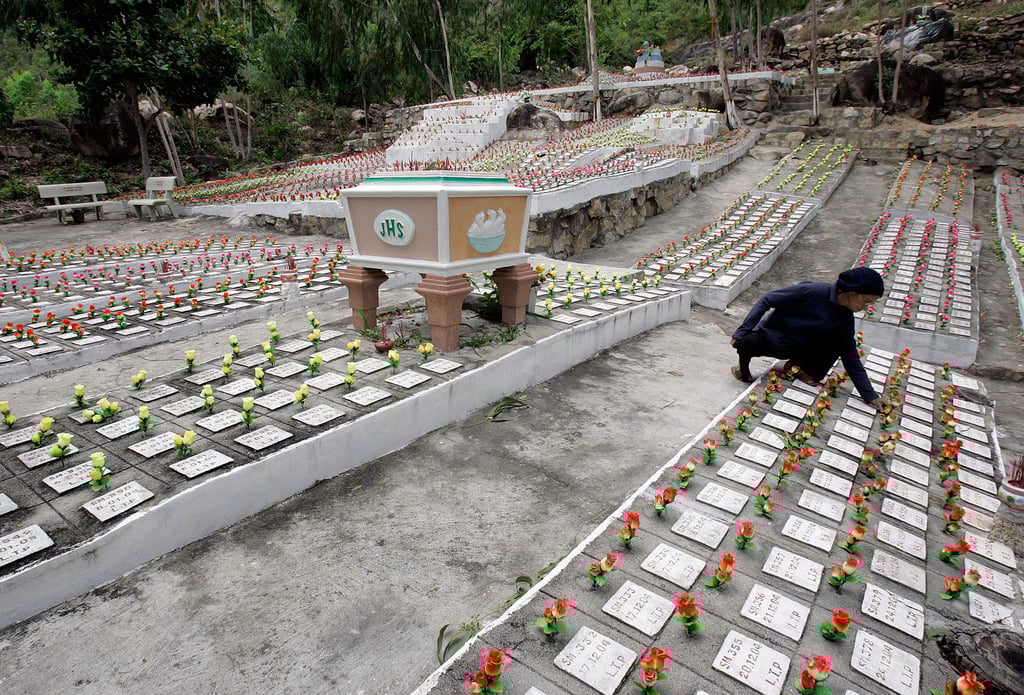 Nguyen Thi Lua fixes artificial roses that have been placed on graves of unwanted fetuses at a cemetery in Nha Trang. Photo: AP Nguyen Thi Lua fixes artificial roses that have been placed on graves of unwanted fetuses at a cemetery in Nha Trang. Photo: AP