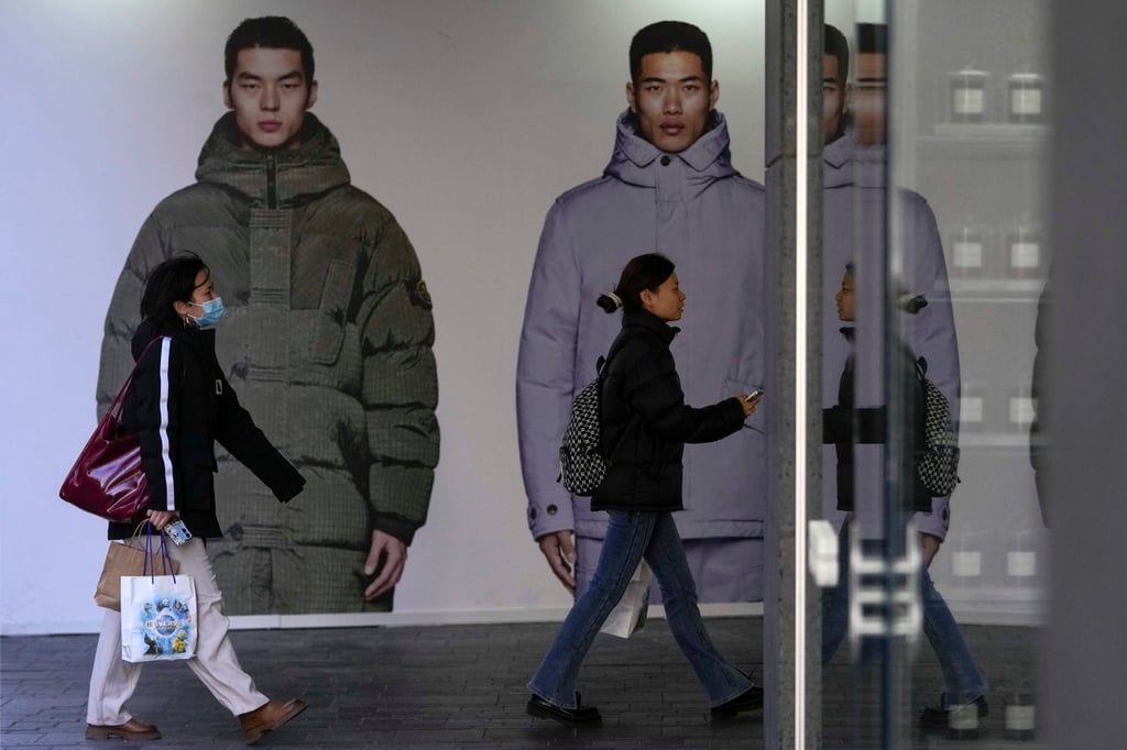Women walk by a winter clothing storefront under renovation at an outdoor shopping mall in Beijing on November 12, 2023. Photo: AP