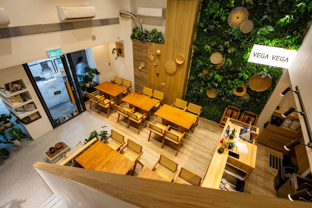 The interior of Macau’s split-level meat-free restaurant Vega Vega includes long wooden tables, bamboo-backed chairs and a striking floor-to-ceiling vertical garden.