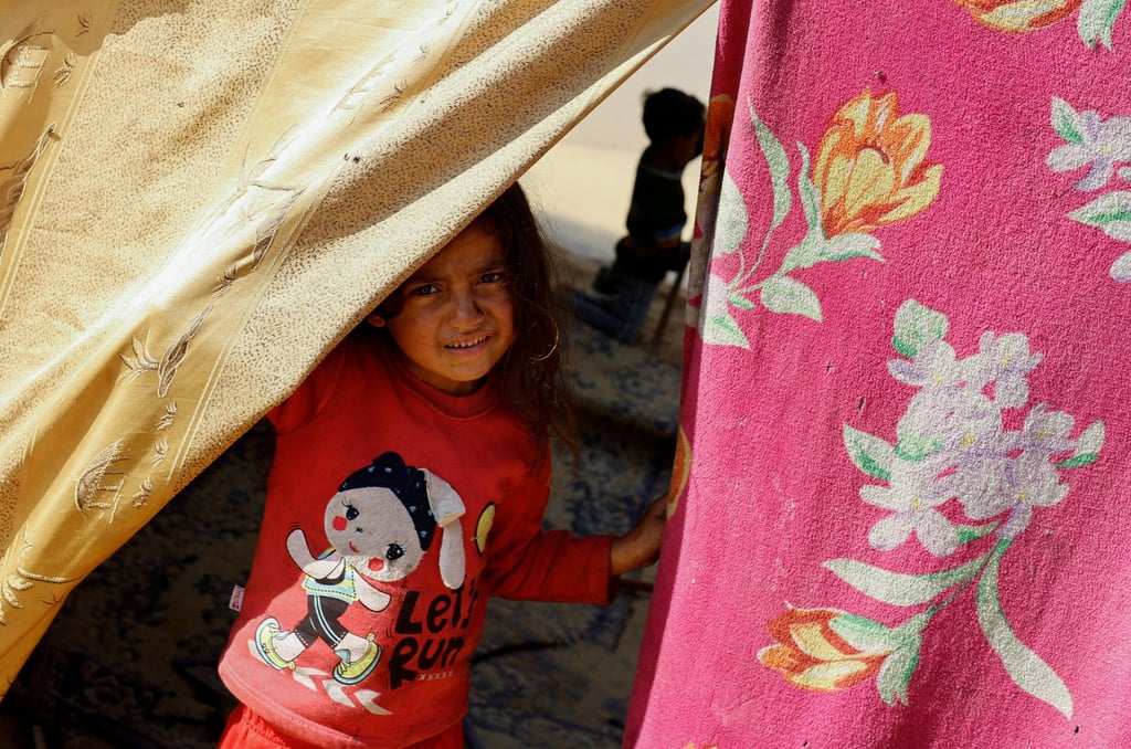 A child looks out of a tent in a camp near the border with Egypt. Photo: Reuters A child looks out of a tent in a camp near the border with Egypt. Photo: Reuters