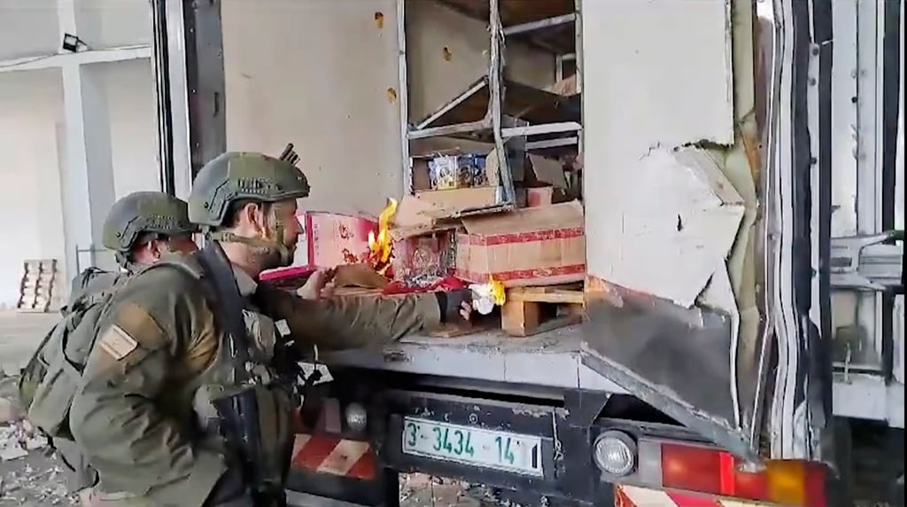 This image made from an undated video shared on X shows Israeli troops trying to burn food and water supplies in the back of a truck in Gaza. Photo: X via AP