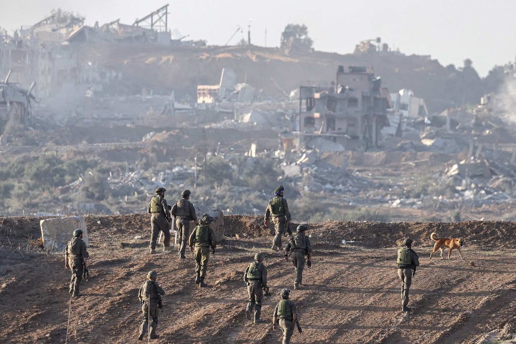 Israeli troops take position on a hill overlooking Gaza on Monday, with destroyed buildings seen in the background. Photo: AFP Israeli troops take position on a hill overlooking Gaza on Monday, with destroyed buildings seen in the background. Photo: AFP