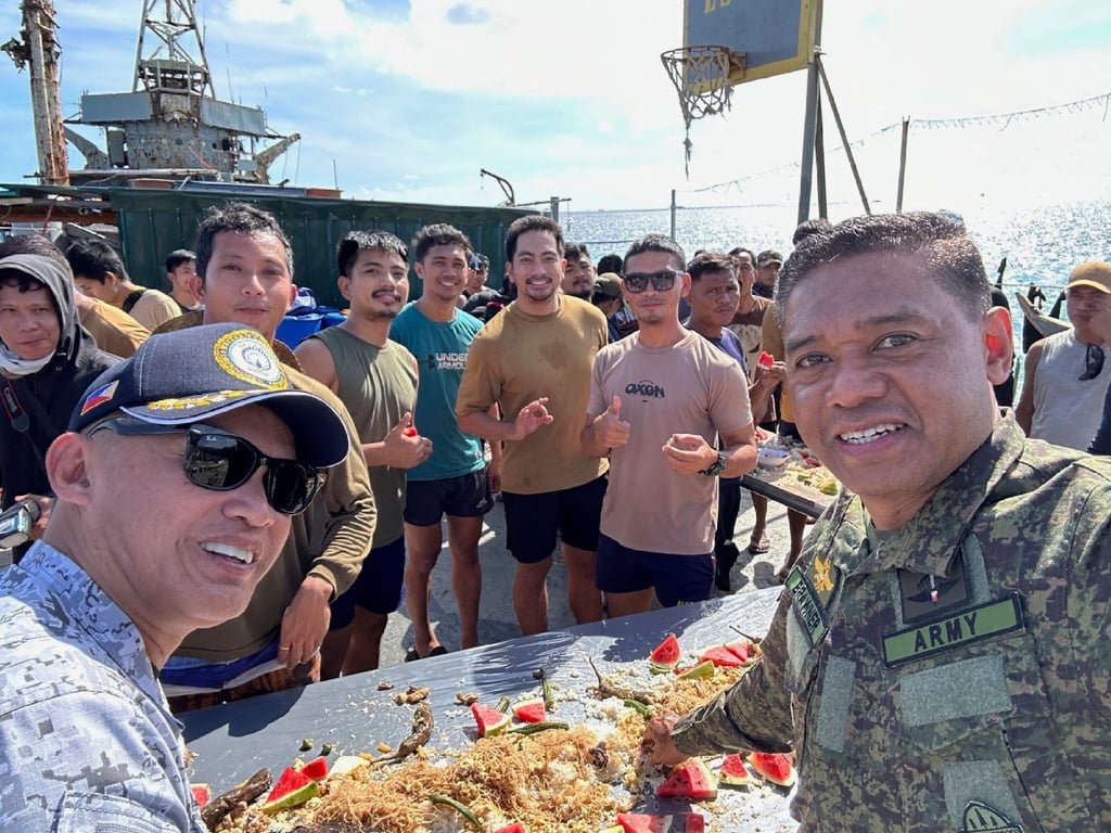 Philippine military chief, General Brawner, right, and vice-admiral Alberto Carlos, left share a meal with Filipino marines and navy personnel stationed aboard the long-marooned BRP Sierra Madre at the Second Thomas Shoal. Photo: PAO via AP