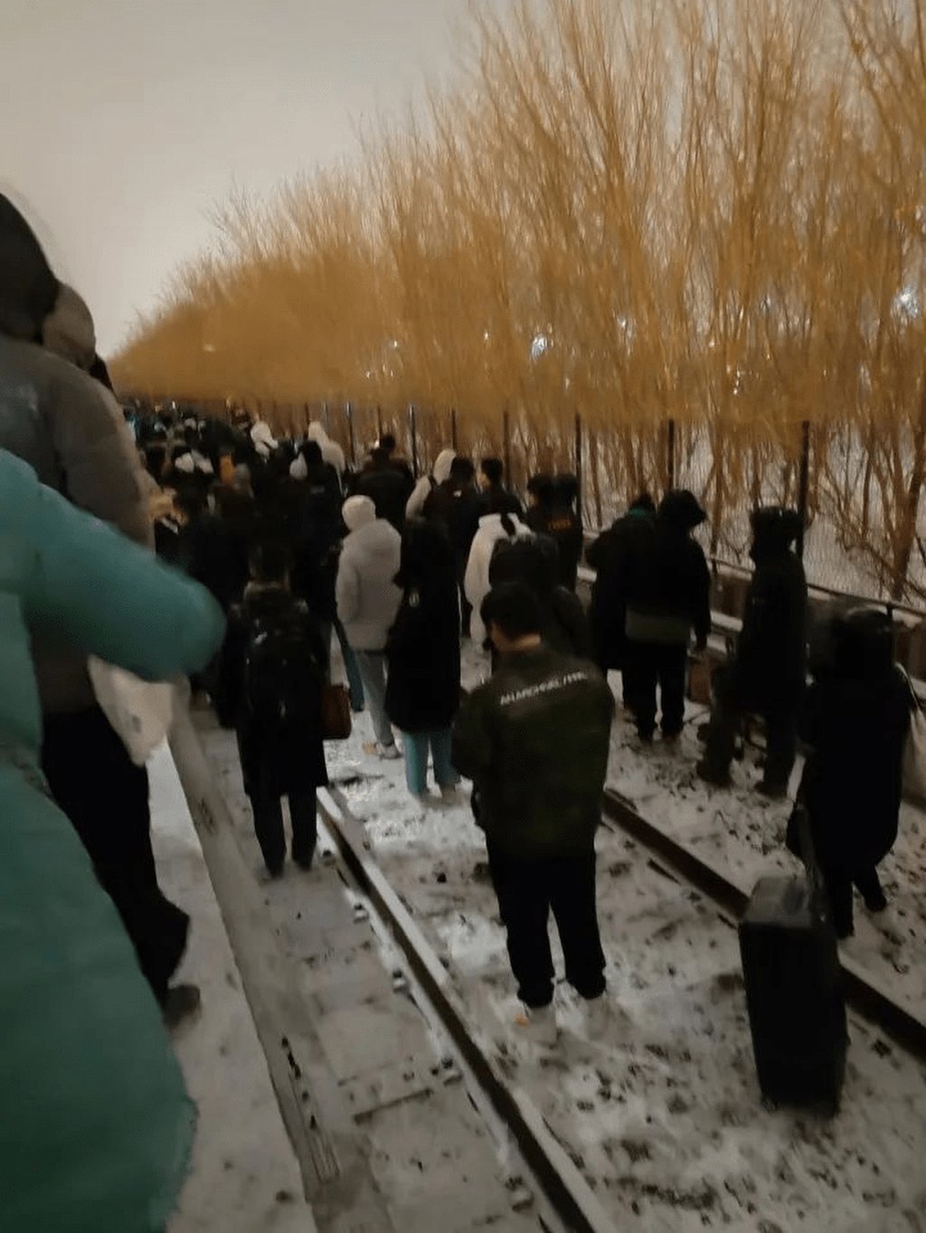 Passengers leave the damaged train and walk through the icy conditions in China’s capital Beijing on Thursday. Photo: Weibo Passengers leave the damaged train and walk through the icy conditions in China’s capital Beijing on Thursday. Photo: Weibo