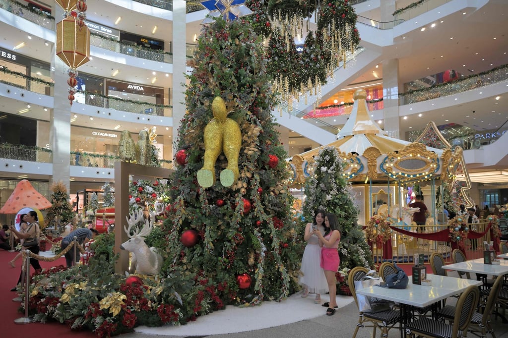 Shoppers take photos next to a decorative Christmas display at a shopping centre in Kuala Lumpur earlier this month. Photo: AFP Shoppers take photos next to a decorative Christmas display at a shopping centre in Kuala Lumpur earlier this month. Photo: AFP