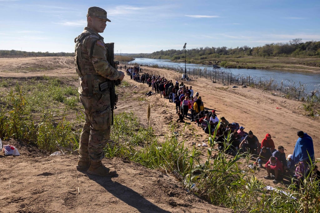 A Texas National Guard soldier watches over a group of more than 1,000 migrants who had crossed from Mexico. Photo: AFP A Texas National Guard soldier watches over a group of more than 1,000 migrants who had crossed from Mexico. Photo: AFP